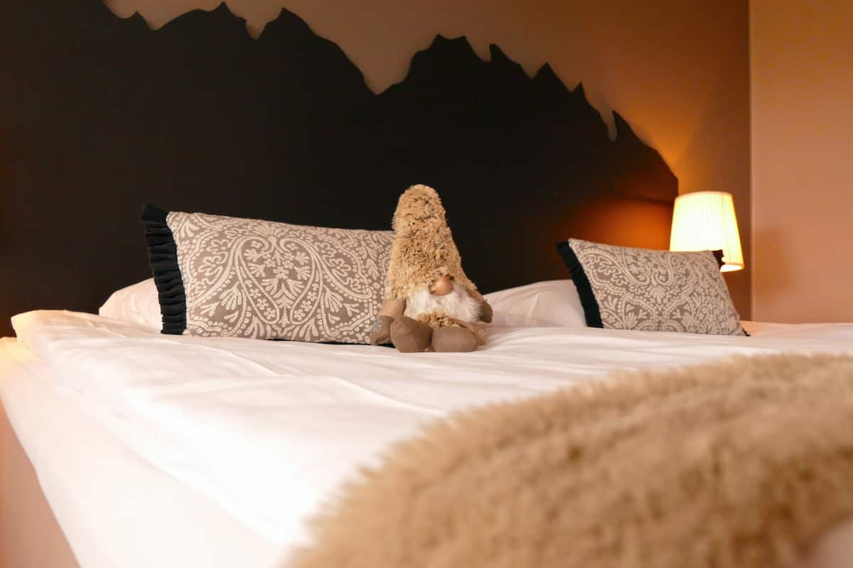 Un lit avec des coussins à motifs et une couverture moelleuse.
