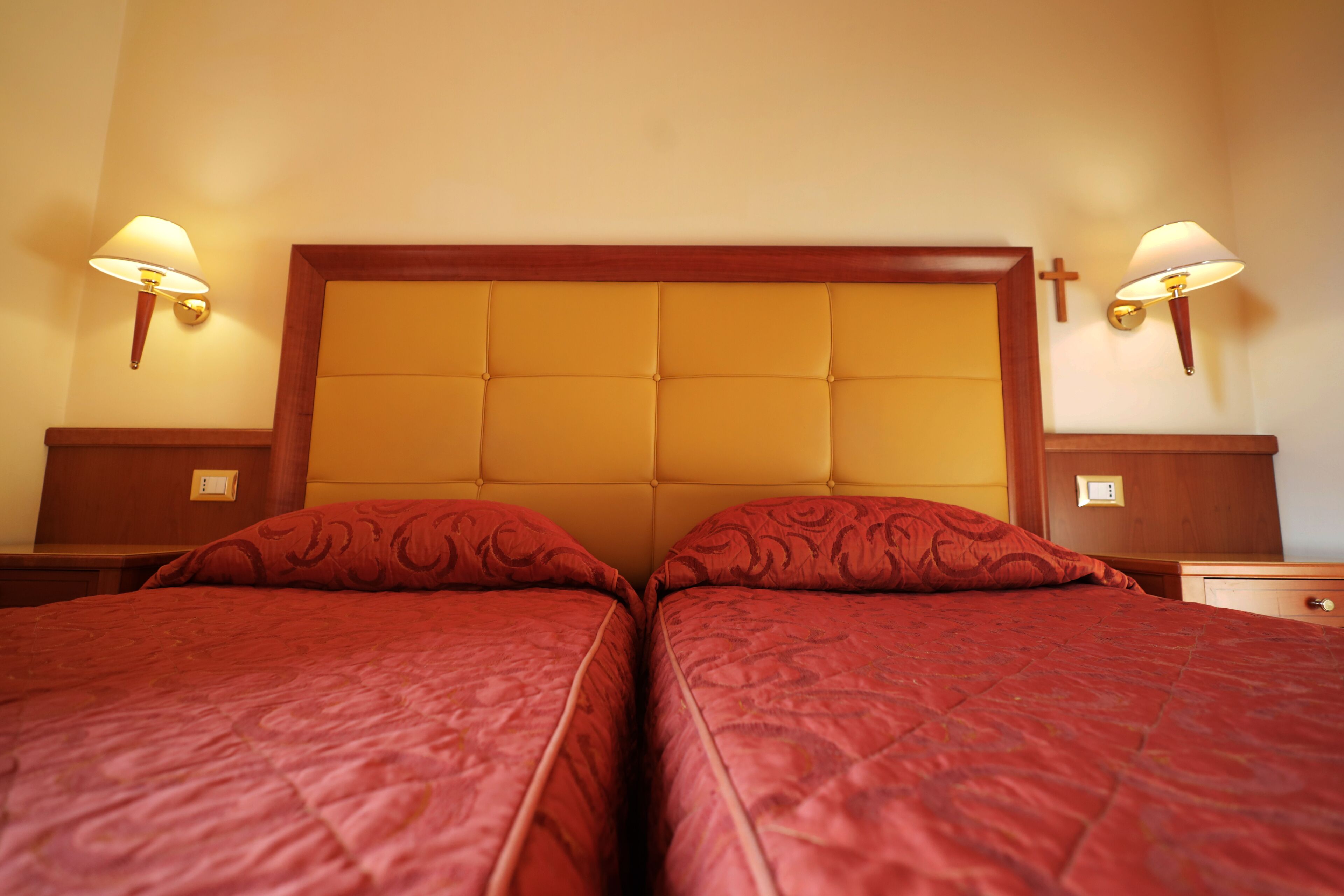 A double bed with a wooden headboard and two bedside tables with lamps.