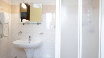 Un baño con lavamanos, espejo y ducha.