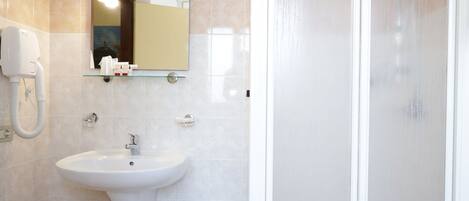 Un baño con lavamanos, espejo y ducha.