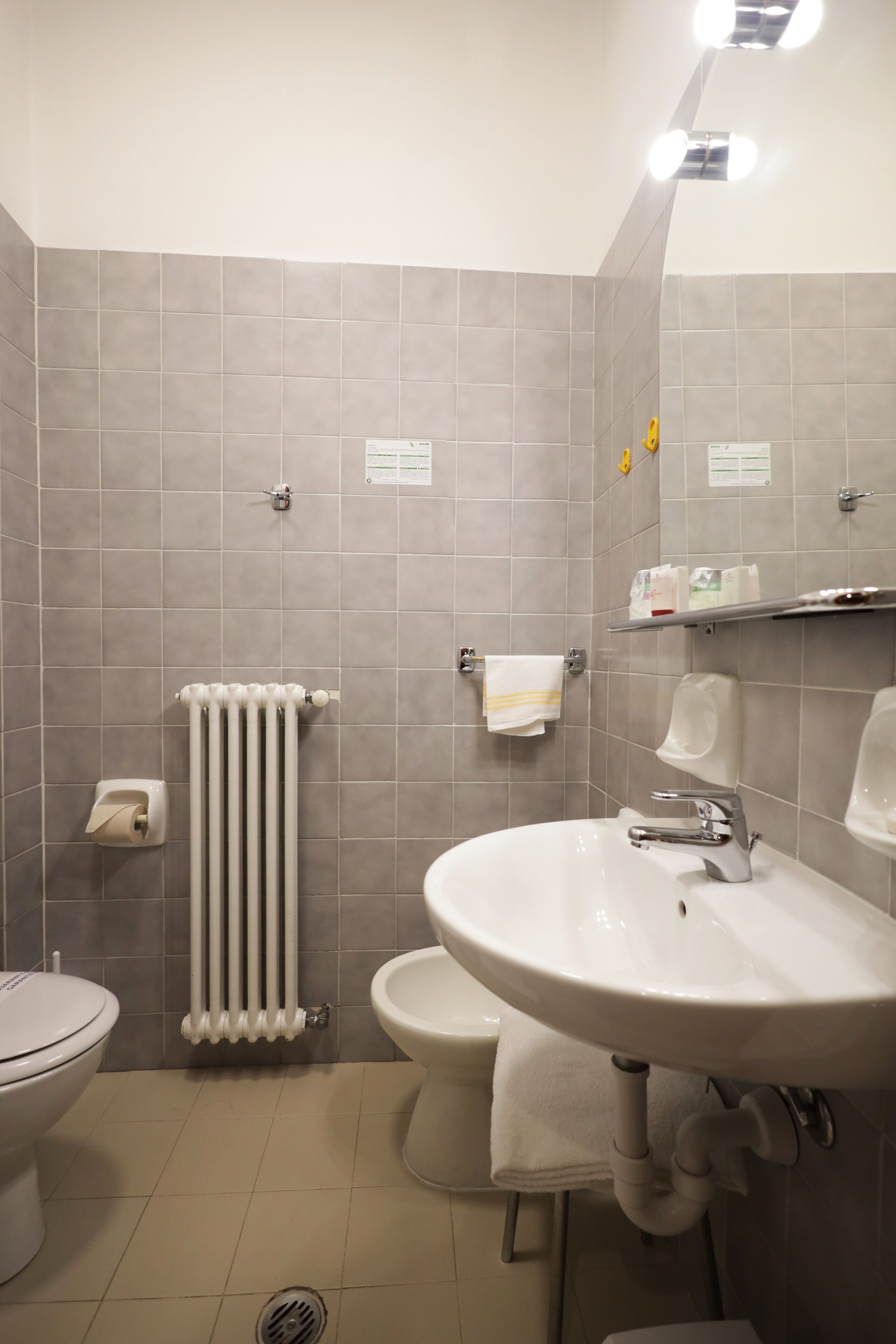 A modern bathroom with a toilet, sink, and radiator.