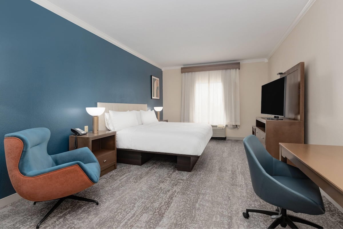 Luxe beddengoed, donzen dekbedden, een bureau, een laptopwerkplek