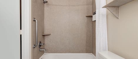 A bathroom with a bathtub, shower, and toilet.