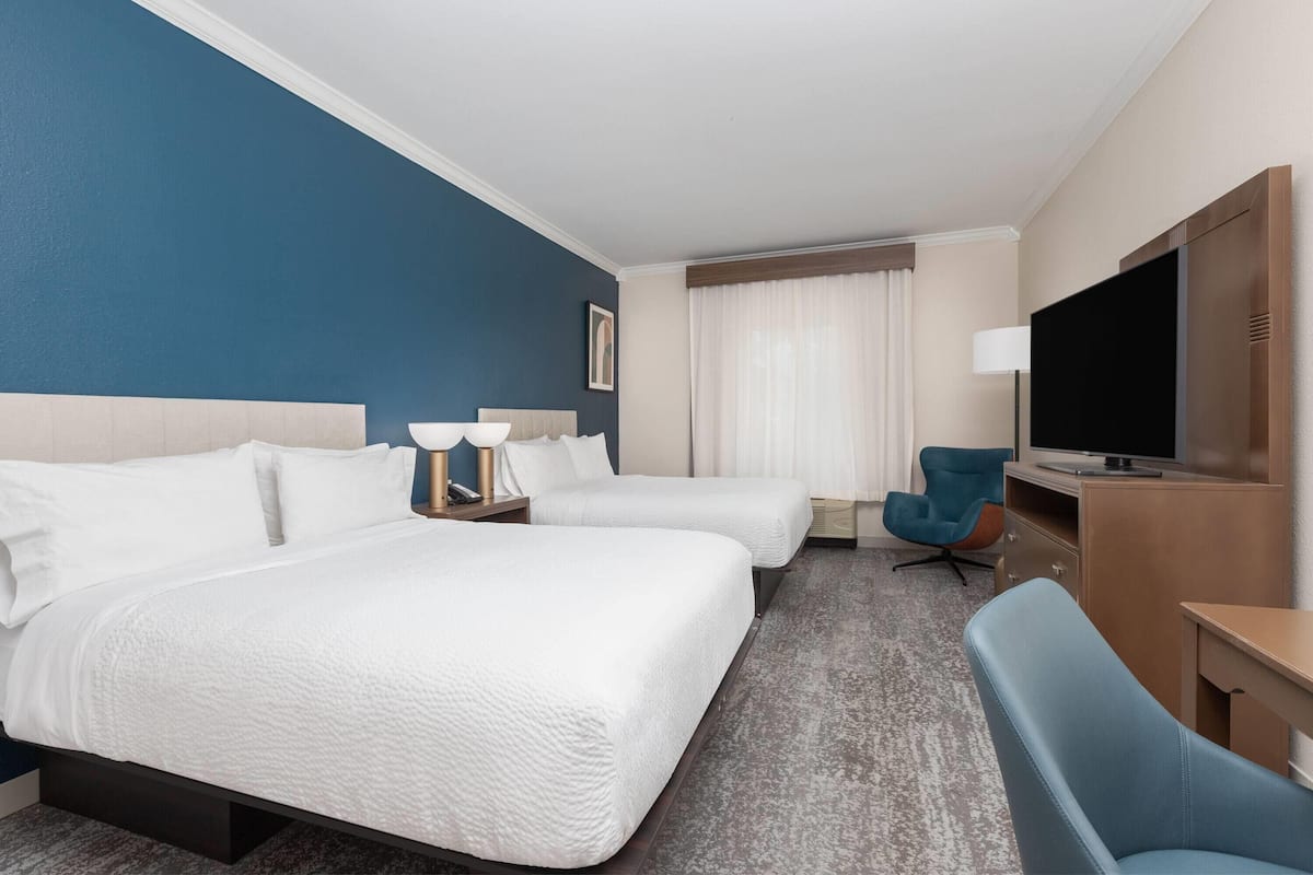 Luxe beddengoed, donzen dekbedden, een bureau, een laptopwerkplek