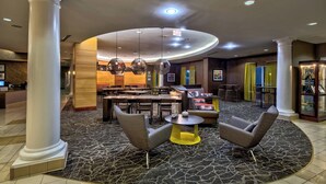 A lobby with a circular seating area, a reception desk, and a bar. - Springhill Suites by Marriott New Bern (New Bern)