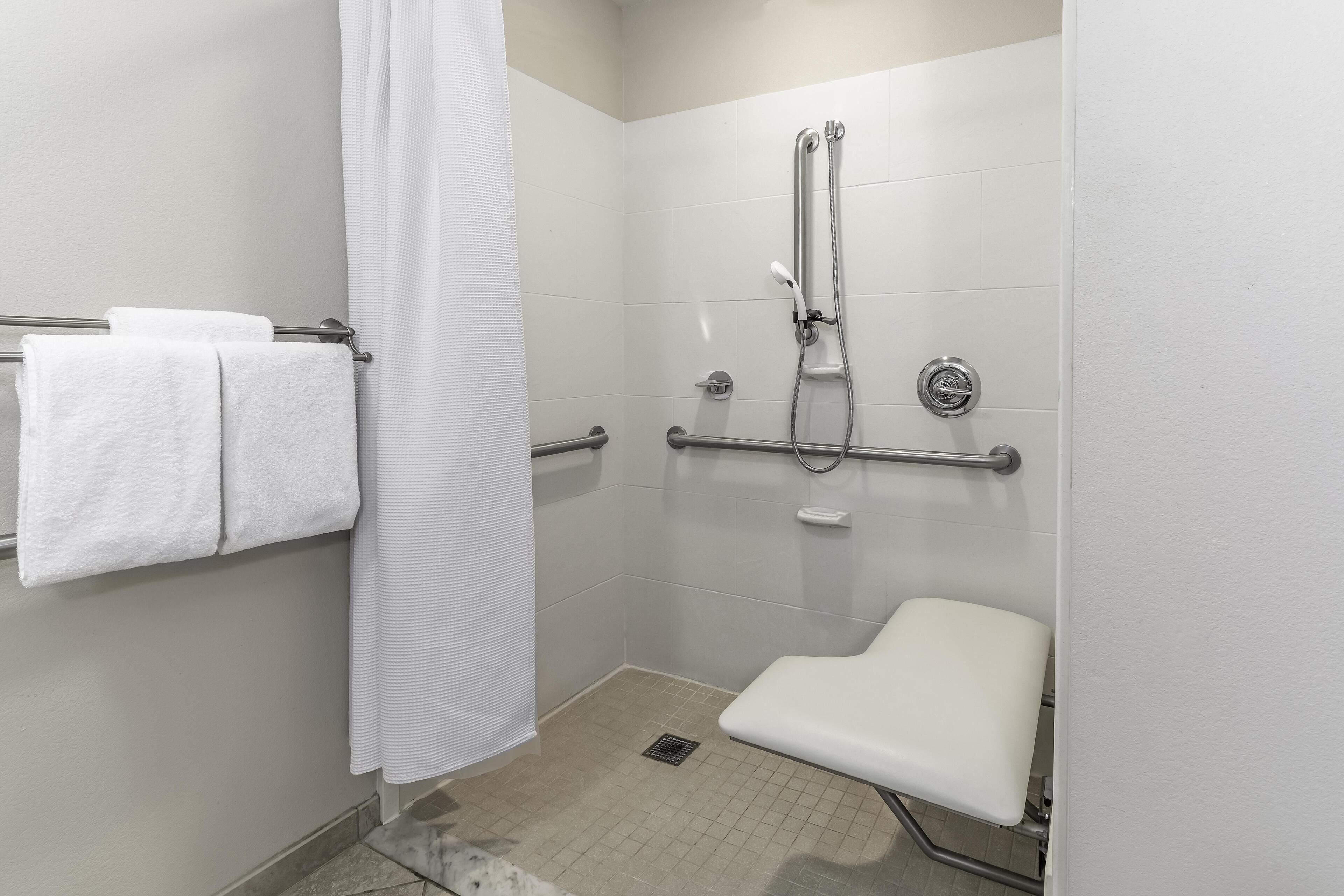 A bathroom with a shower, a toilet, and a towel rack.