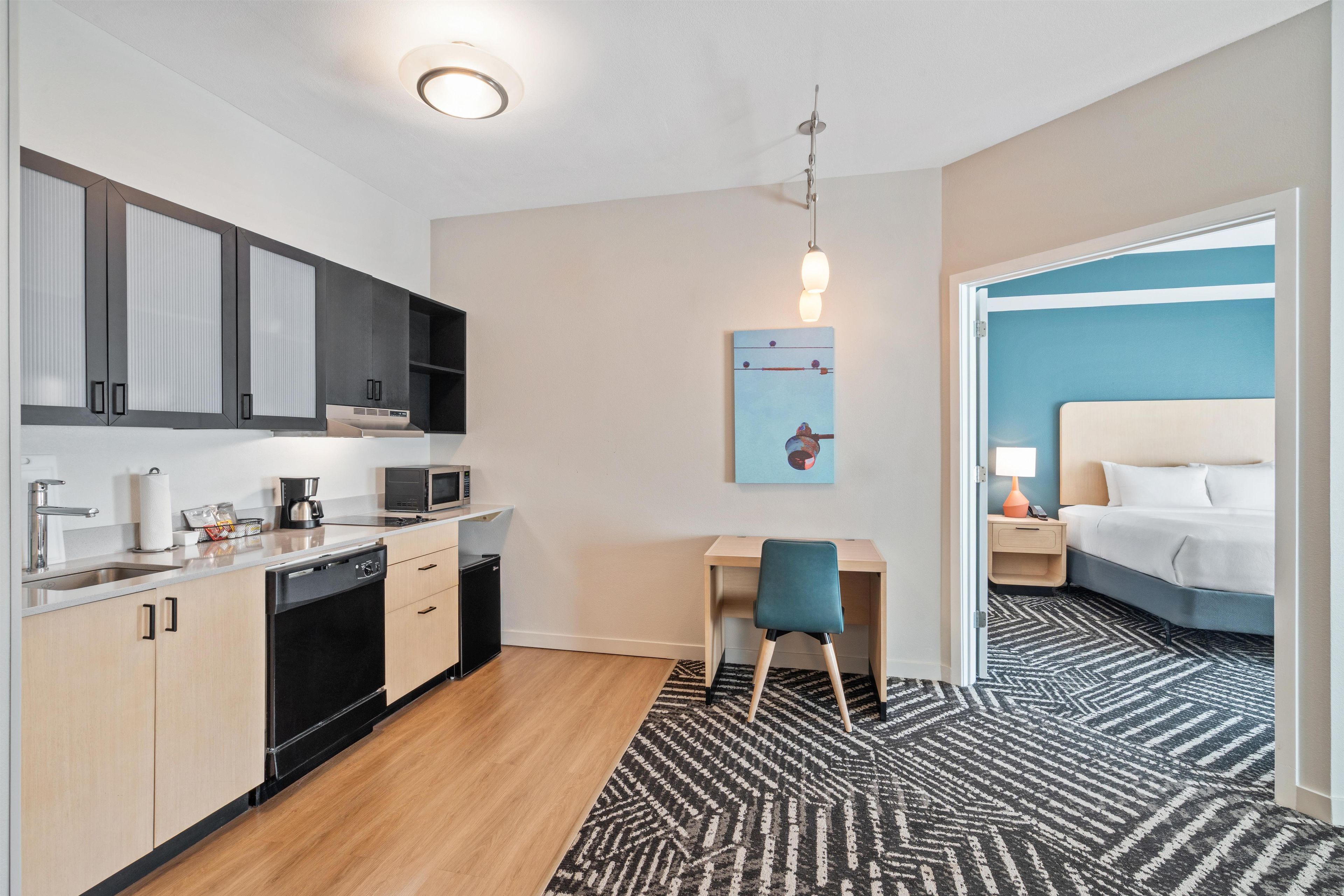 Une chambre d’hôtel compacte comprenant un coin cuisine, un espace repas, un lit et une vue sur l’extérieur.