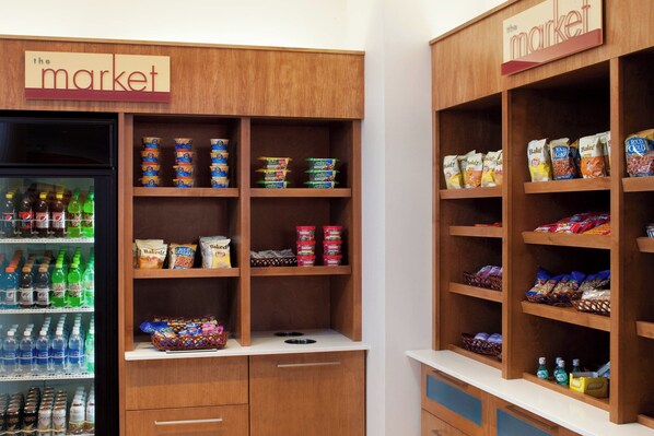 A self-service snack and beverage station with multiple shelves stocked with various products. - SpringHill Suites by Marriott Saginaw (Saginaw)