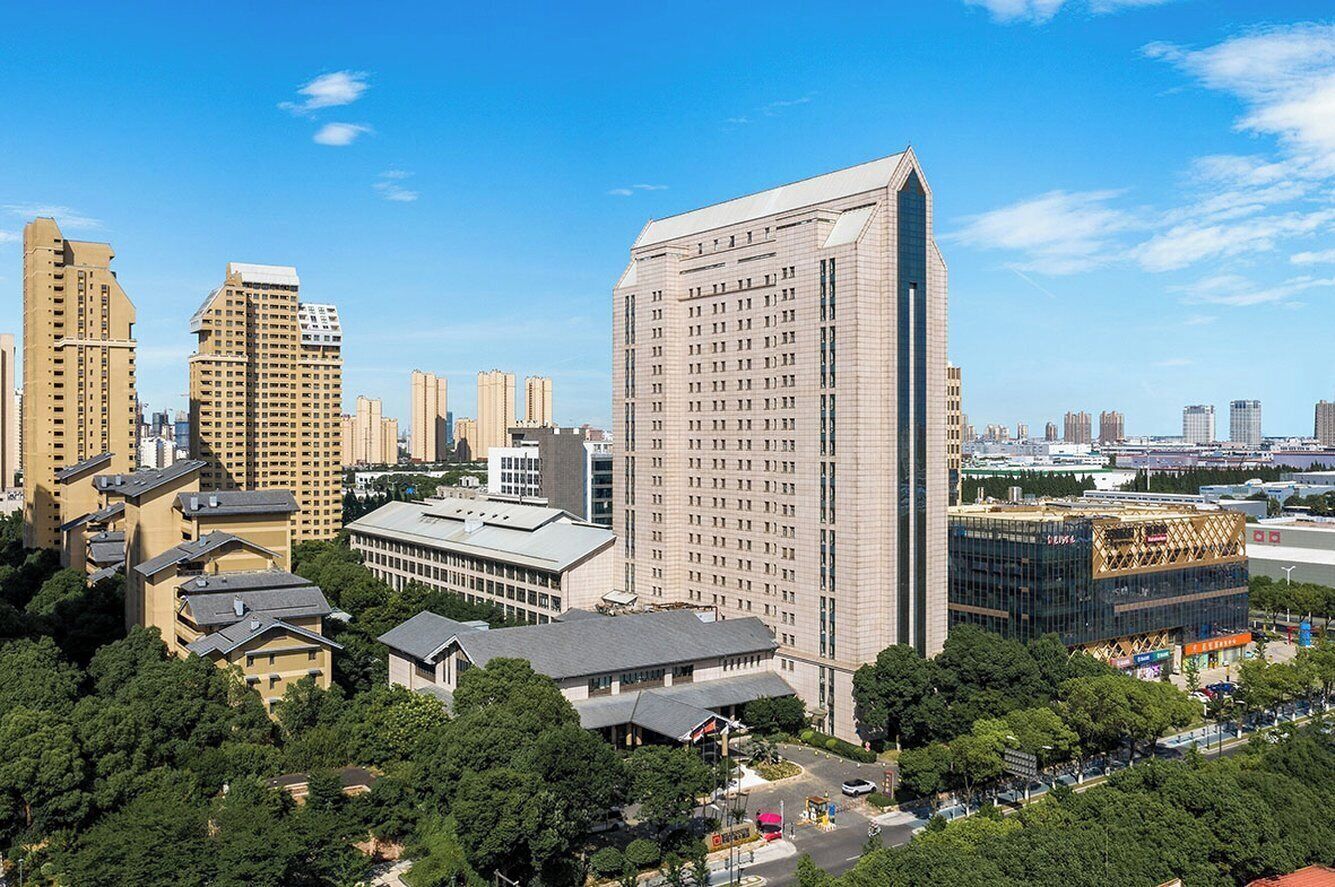 A cityscape with modern high-rise buildings, a mix of residential and commercial structures, and a clear blue sky.
