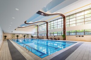 Una piscina techada, sillones reclinables de piscina