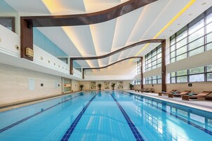 Una piscina techada, sillones reclinables de piscina