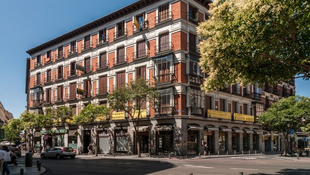 A multi-story building with a traditional facade, featuring a mix of brick and stone materials. - Hostal Gallardo (Madrid)