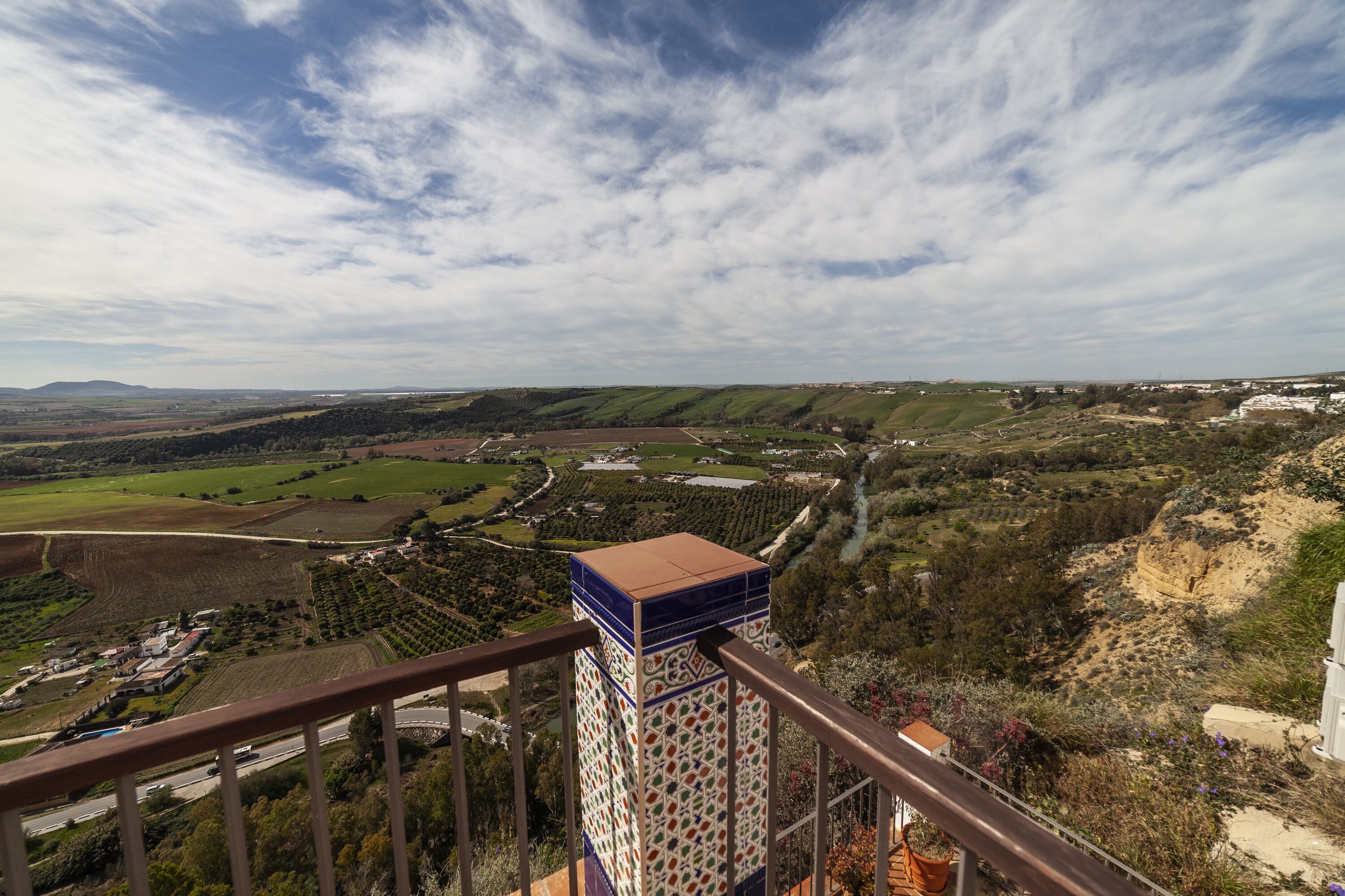Una vista panorámica de un paisaje rural con una estructura de tejas al frente.