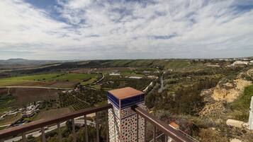 Una vista panorámica de un paisaje rural con una estructura de tejas al frente.
