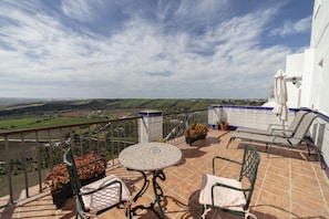 A terrace with a round table and two chairs, overlooking a scenic landscape. - Hotel El Convento (Arcos de la Frontera)