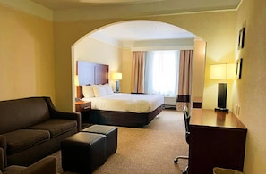 A hotel room with a bed, a sofa, a desk, and a lamp. - Comfort Inn & Suites, Odessa I-20 (Odessa)