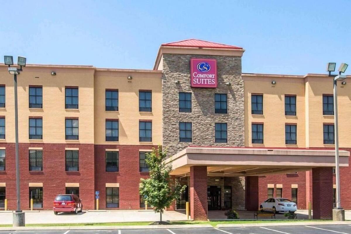 Een Comfort Suites hotel met een gevel van baksteen, een stenen toren en een overdekte ingang.