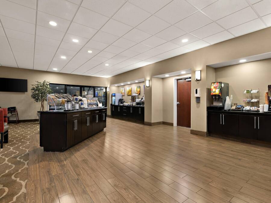 Un amplio vestíbulo de hotel con mostrador de recepción, zona de estar y una mesa de buffet.