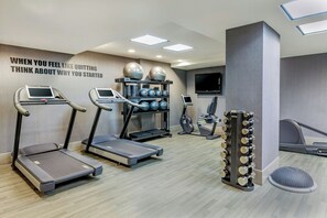 A modern gym with treadmills, a weightlifting station, and a motivational quote on the wall. - Fairfield by Marriott New York Manhattan Times Square (New York)