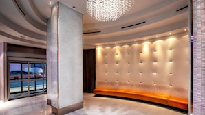 A modern lobby with a curved seating area, a textured wall, and a ceiling light fixture. - Fairfield by Marriott New York Manhattan Times Square (New York)