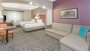 A hotel room with a bed, two bedside tables, a sofa, a desk with a chair, and a television. - La Quinta Inn & Suites by Wyndham Oklahoma City -Yukon (Yukon)
