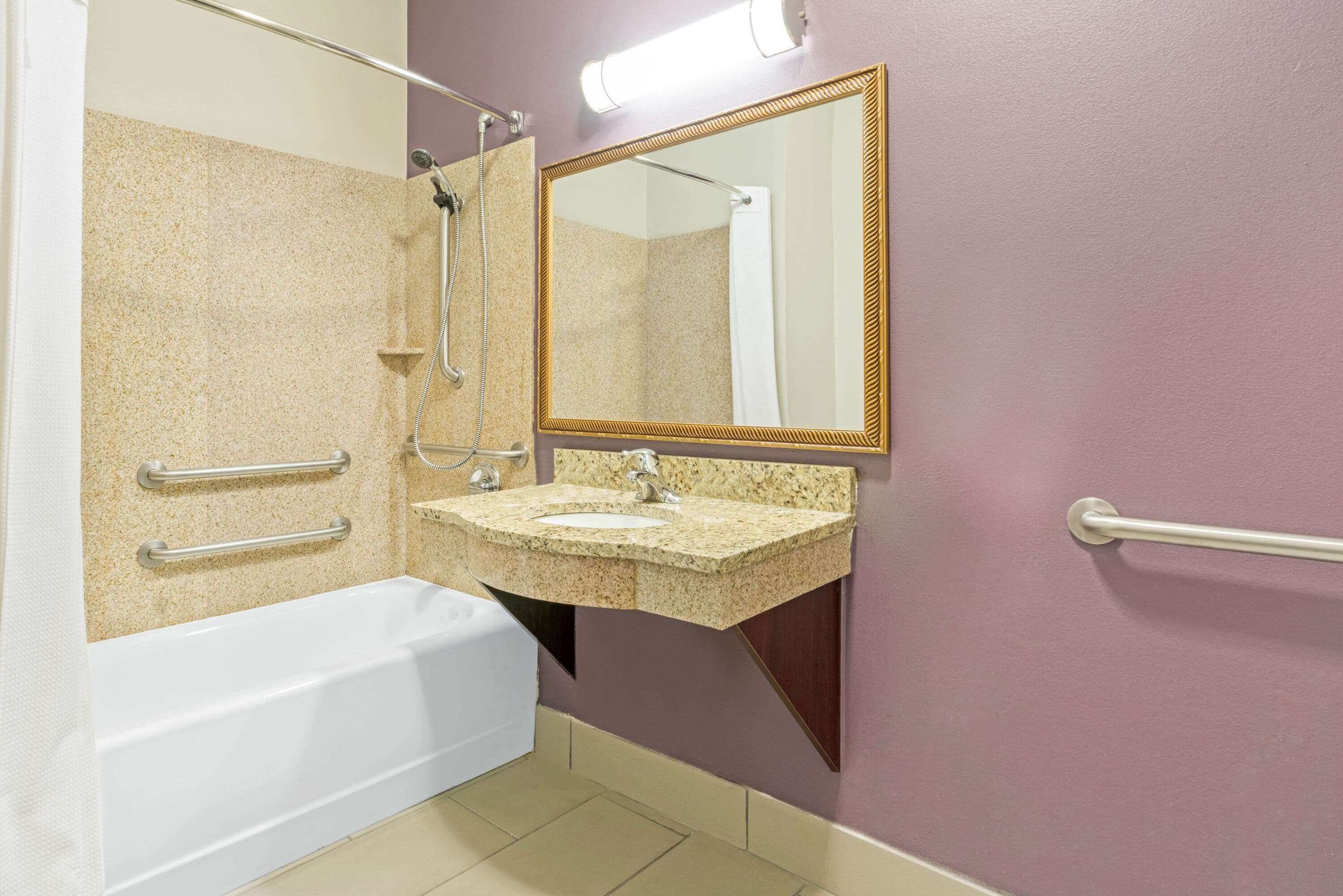 A bathroom with a bathtub, a sink, a shower, and a mirror.