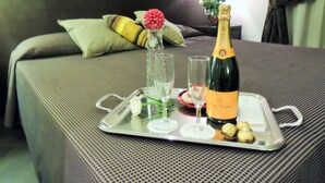 A bed with a tray containing a bottle of champagne, glasses, and a flower arrangement. - Florida rooms - comfort Hotel (Rome)