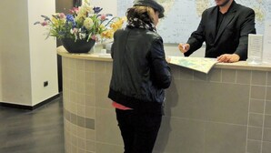 A reception desk with a world map in the background. - Florida rooms - comfort Hotel (Rome)