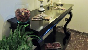 A reception desk with a glass vase of dried flowers, a candle, and a lamp. - Florida rooms - comfort Hotel (Rome)