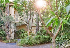 A building with a stone facade, surrounded by lush greenery and trees.