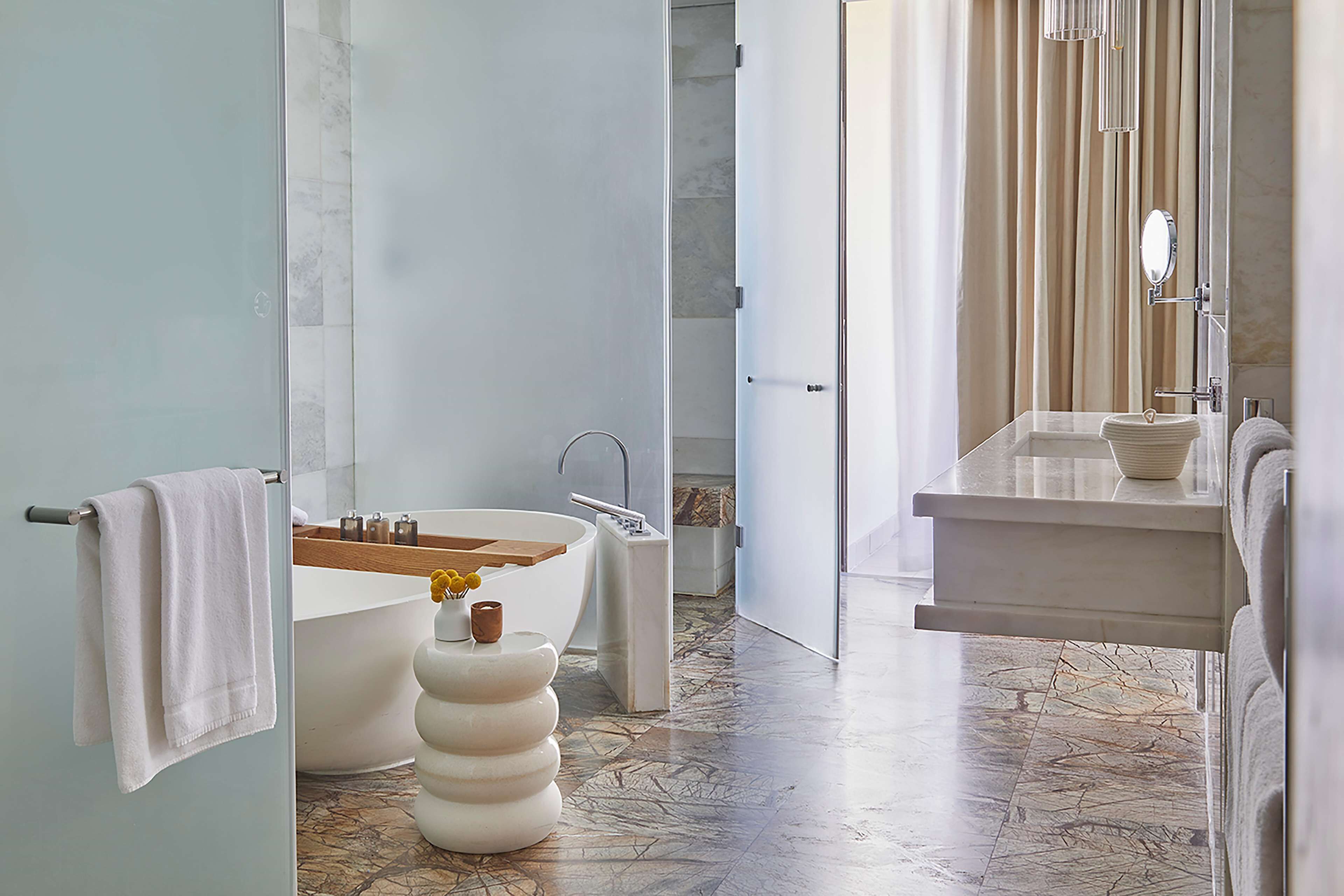 A modern bathroom with a bathtub, a sink, and a mirror.