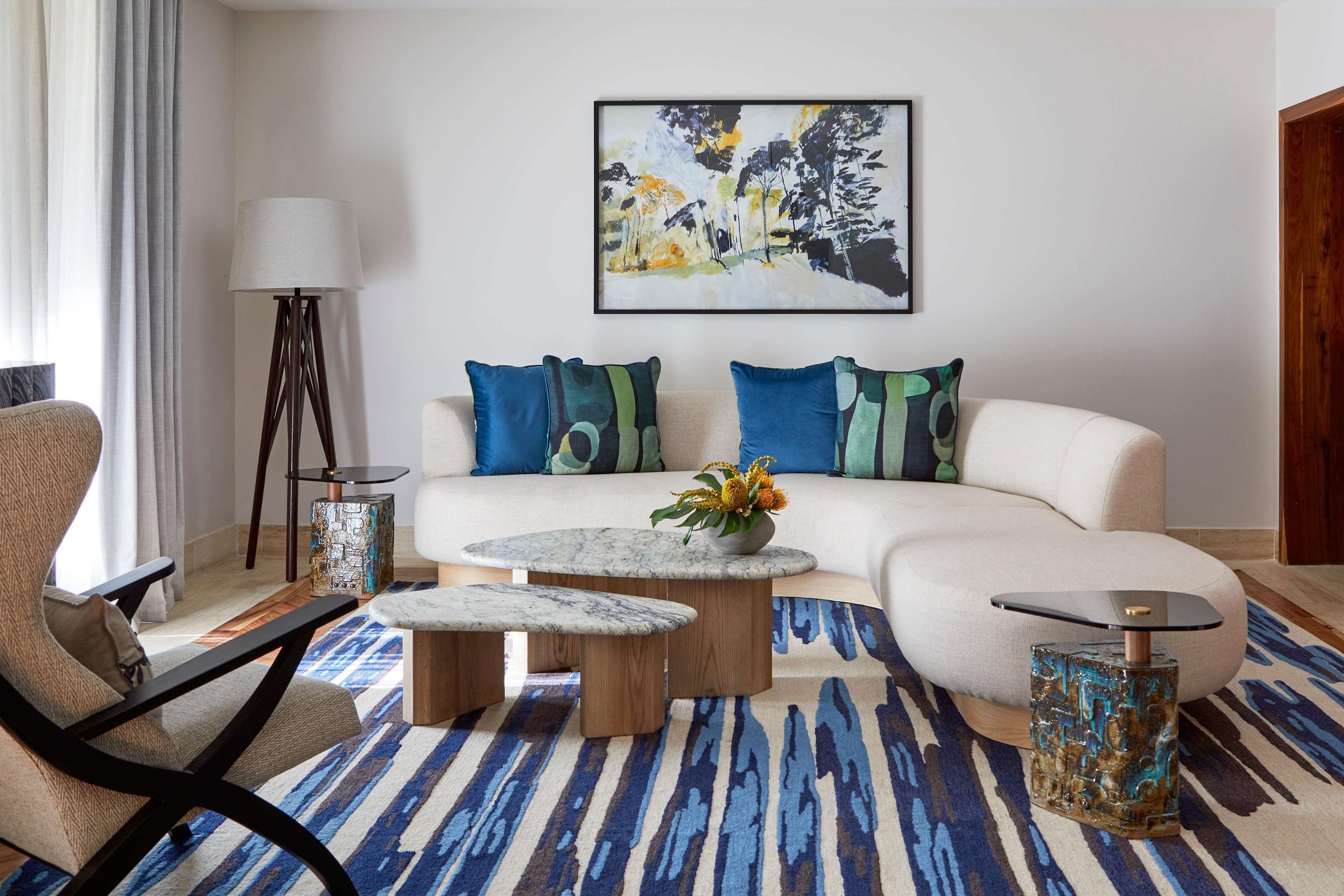 A modern living room with a sectional sofa, a round coffee table, a side table, and a floor lamp.