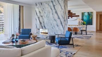 A modern living room with a marble accent wall, blue and white furniture, and a city view.