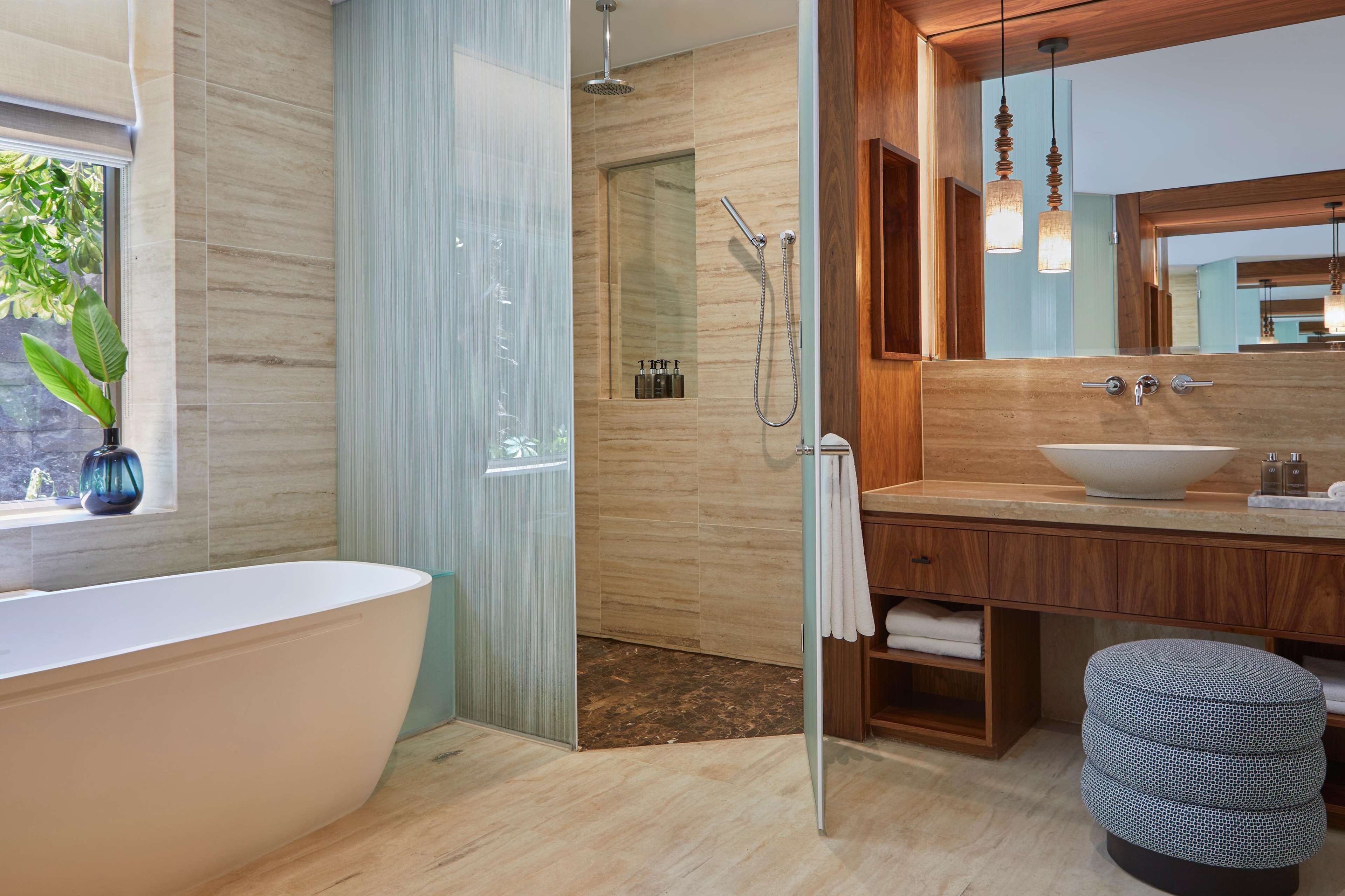 Une salle de bain moderne avec une baignoire sur pieds, une douche à l’italienne, un grand miroir et un meuble-lavabo en bois.