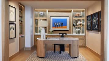 A modern kitchen with a central island, built-in shelving, and a large framed artwork above the island.