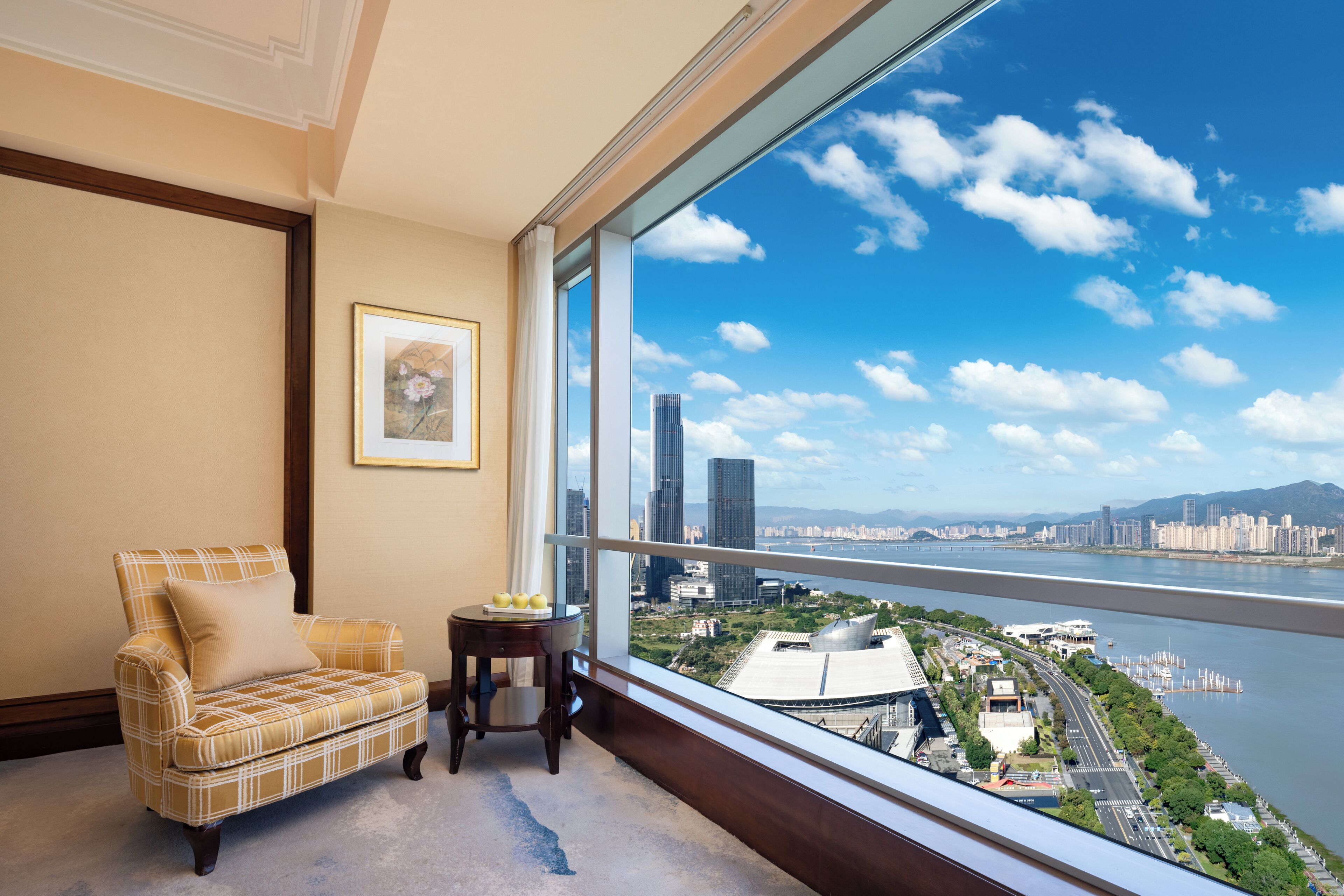 A room with a large window overlooking a cityscape and a river.