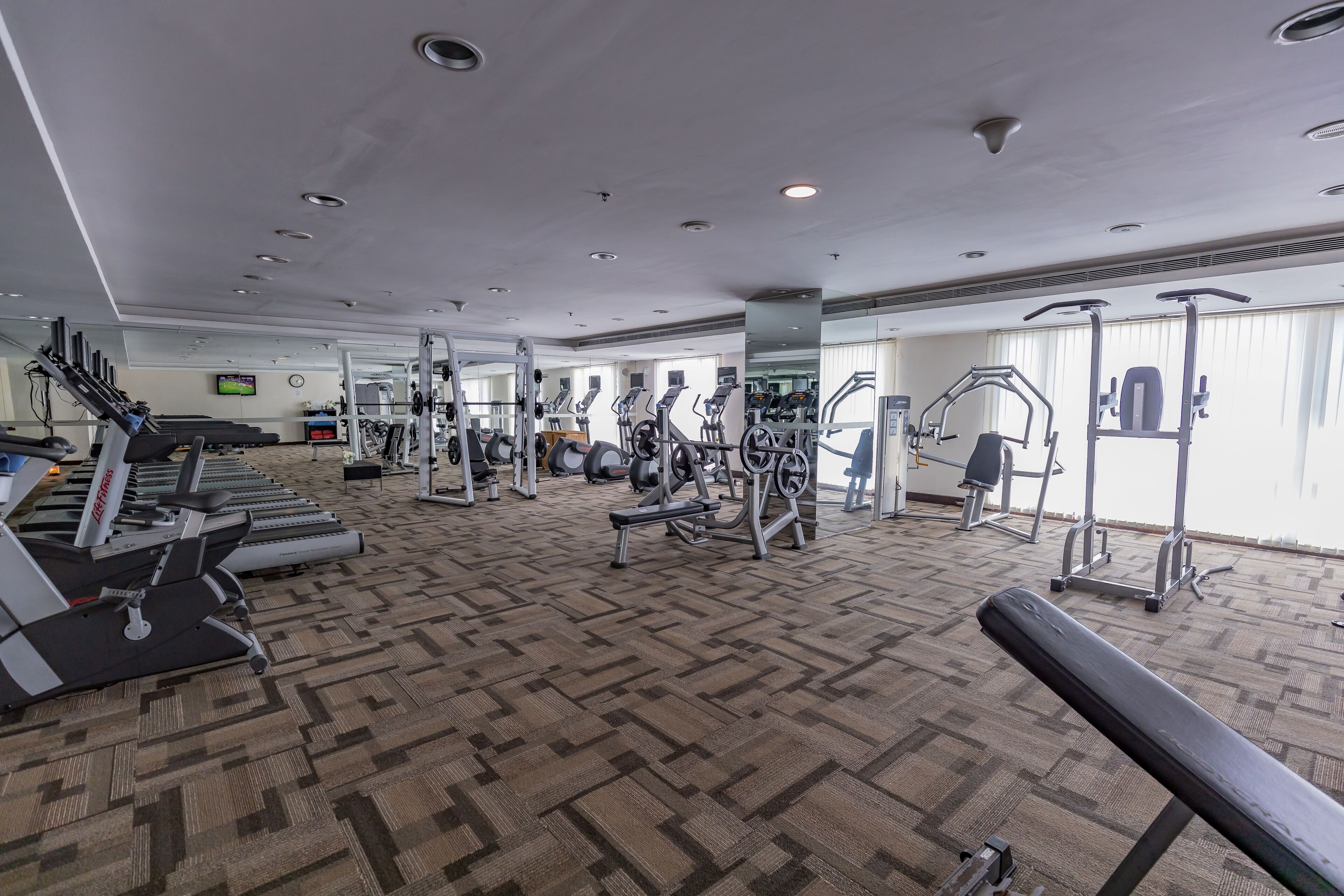 A gym with treadmills, weight machines, and exercise equipment.
