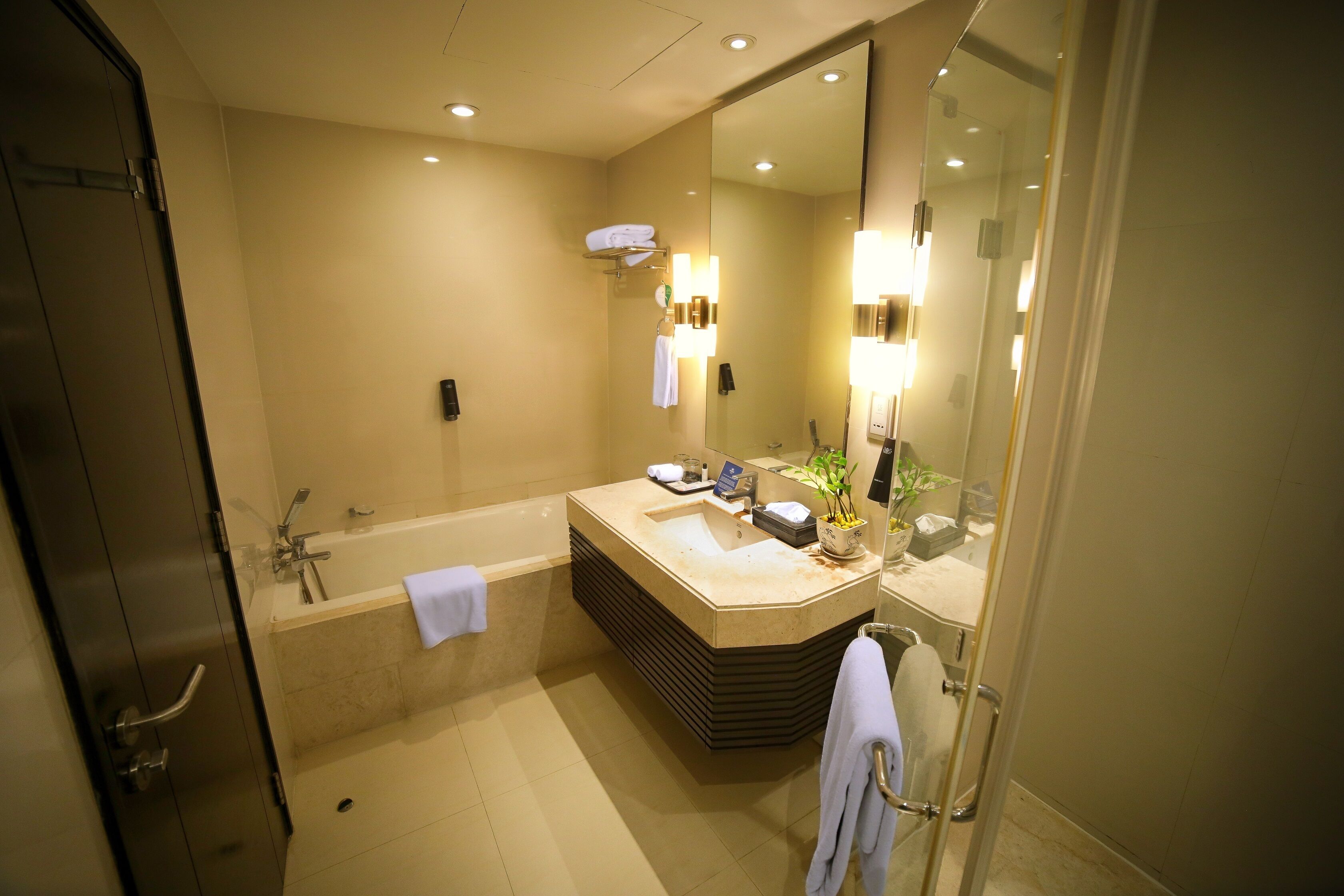 A modern bathroom with a large bathtub, a sink, and a mirror.