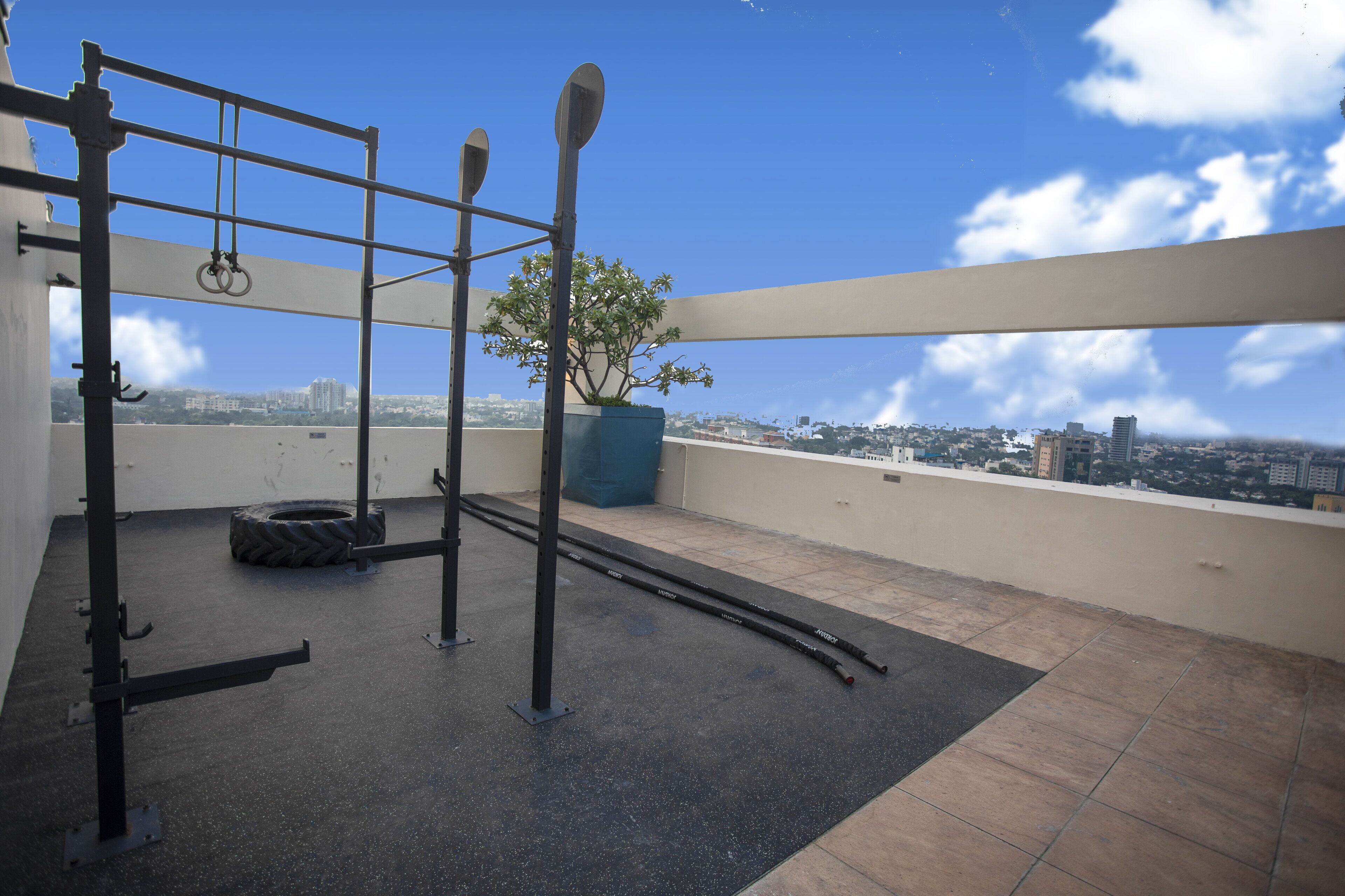 Un gimnasio con equipamiento en una terraza en la azotea, con vistas a la ciudad.