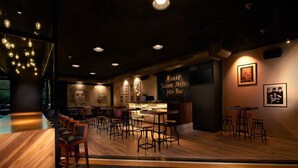 Un restaurante acogedor con suelo de madera, asientos de bar y un menú en la pizarra.