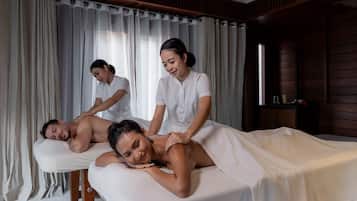 A massage therapy room with a wooden interior, a massage table, and a bowl of flowers on the floor.