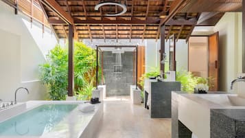 Un área de spa con una bañera grande, dos lavamanos, ducha y techo de madera.