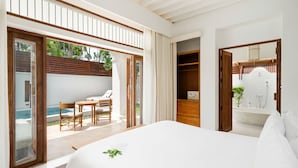 A modern bedroom with a large bed, a bathroom with a sink and mirror, and a balcony with a pool and seating area. - SALA Samui Choengmon Beach (Koh Samui)