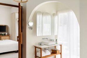Een moderne badkamer met een grote spiegel, een wastafel en een houten wastafelmeubel.