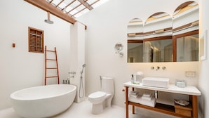 A modern bathroom with a freestanding bathtub, a toilet, a shower, and a vanity with a mirror. - SALA Samui Choengmon Beach (Koh Samui)