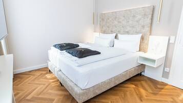 A modern hotel room with a large bed, a bedside table, and a TV.
