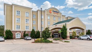 A Comfort Suites hotel with a central entrance, multiple windows, and a parking lot. - Comfort Suites Vicksburg (Vicksburg)