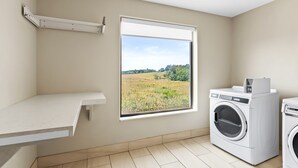 Un cuarto de lavado con un ventanal amplio, una lavadora y una encimera.