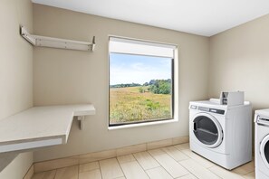 A laundry room with a large window, a washing machine, and a countertop. - Holiday Inn Express Hotel & Suites Pauls Valley by IHG (Pauls Valley)