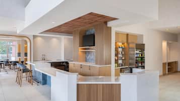 Una cocina moderna con una isla central, electrodomésticos integrados y una zona de comedor con taburetes de bar.